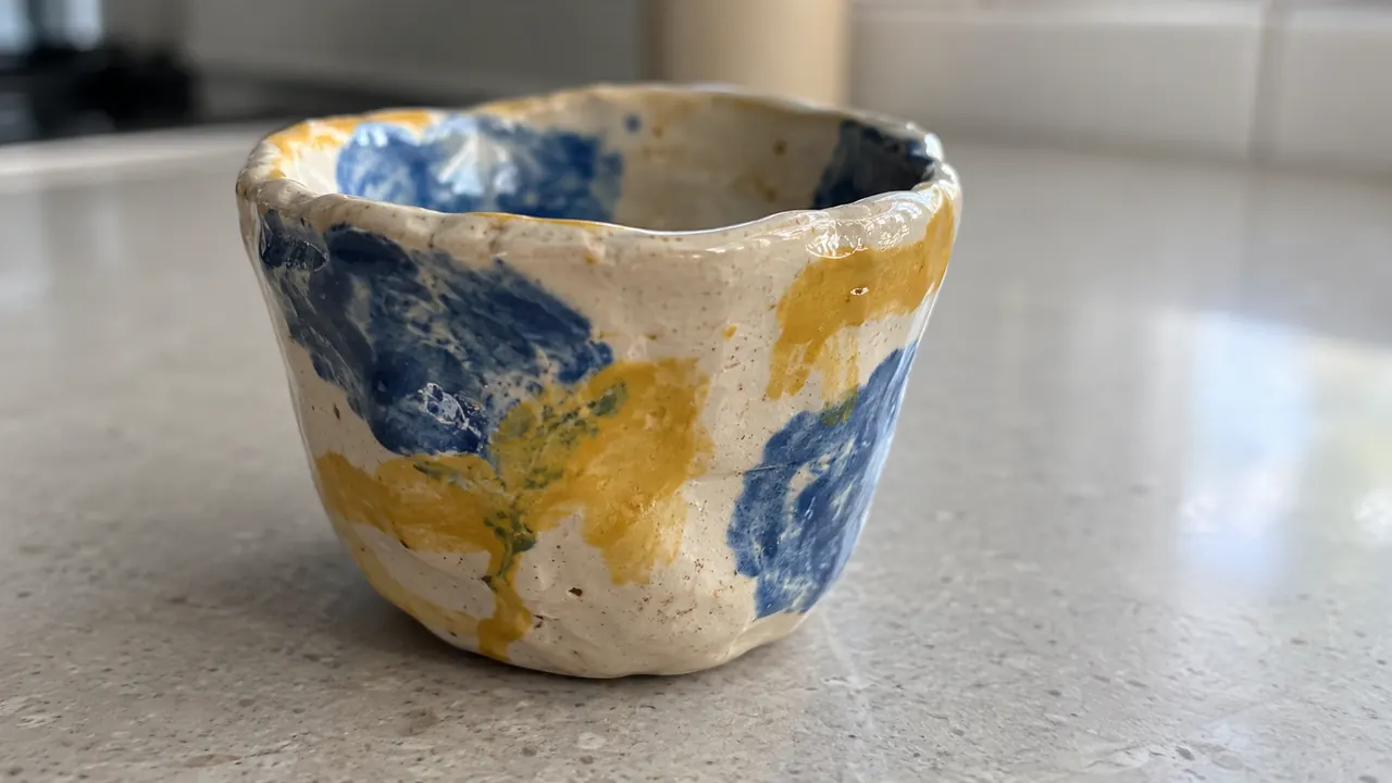 青と黄色で色付けされた小さな陶器のカップ